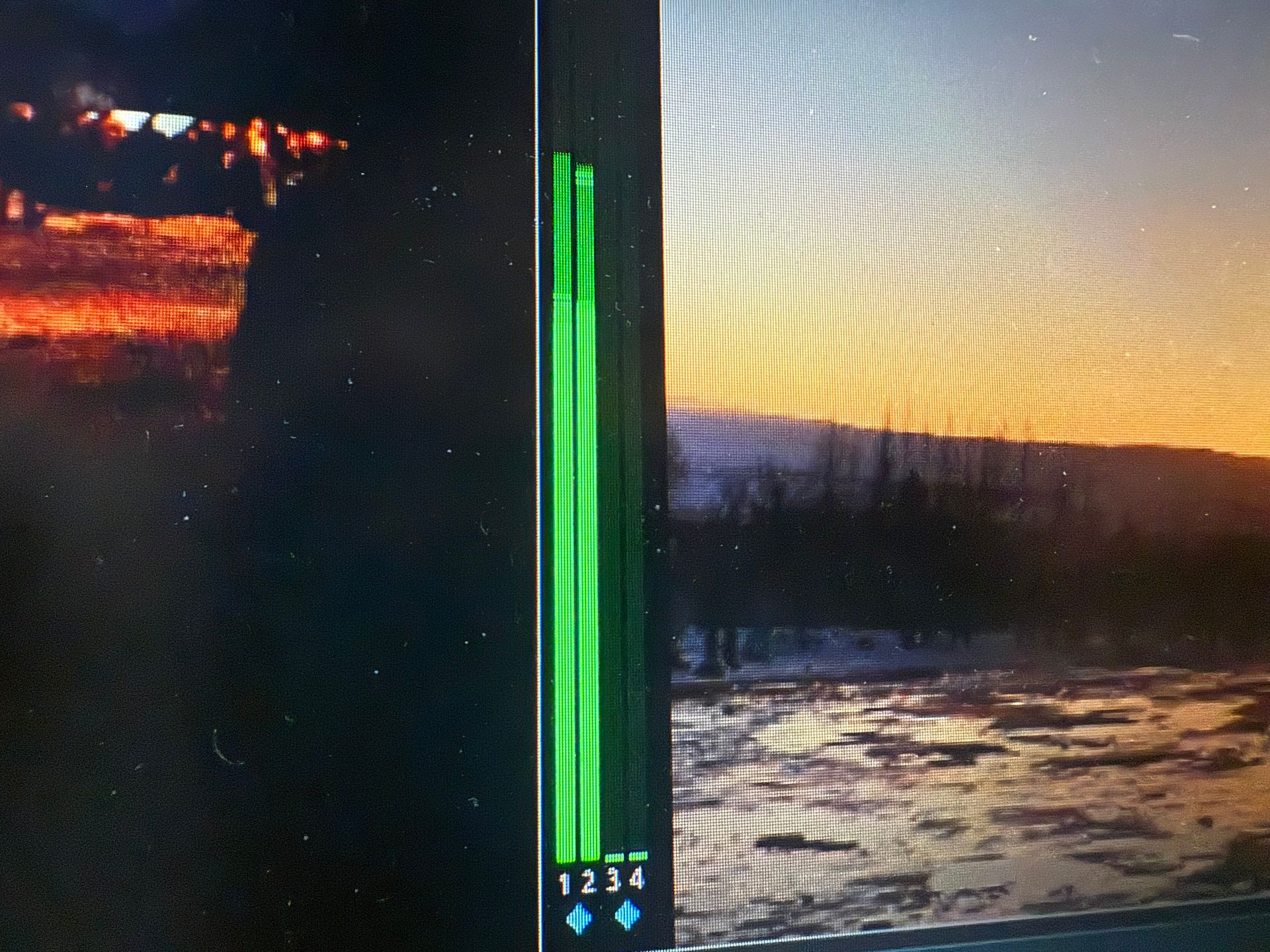 Close-up of Laika multiviewer showing green audio level meters with channels 1-2-3-4 between two sunset video feeds